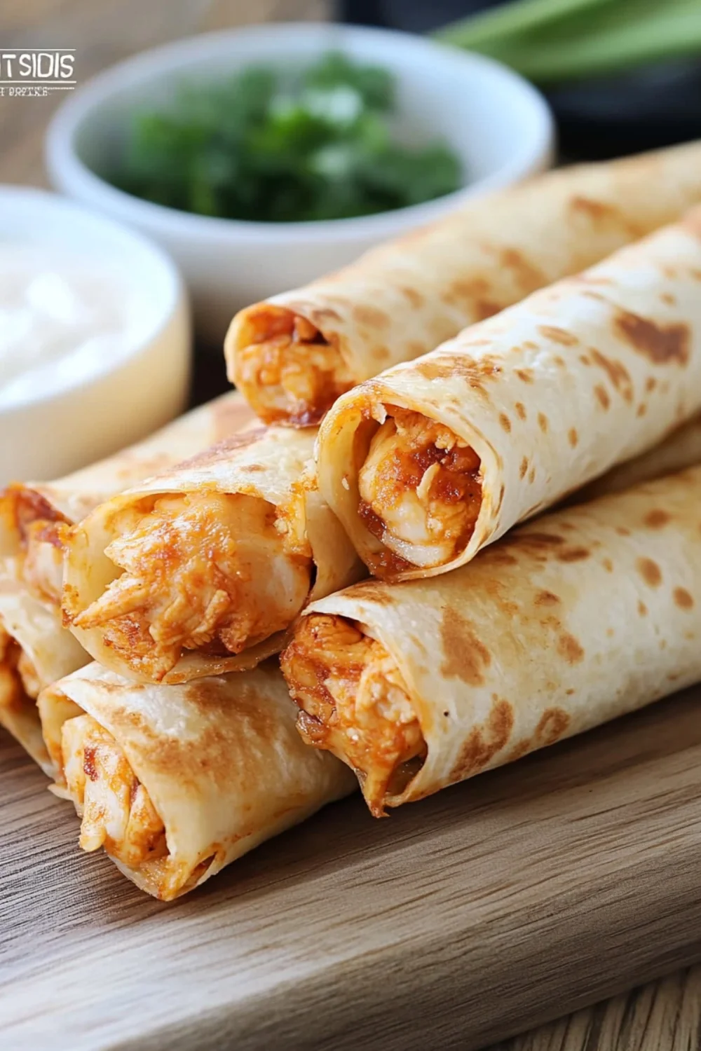 A stack of crispy, golden chicken taquitos filled with seasoned chicken, served with a side of creamy dipping sauce.